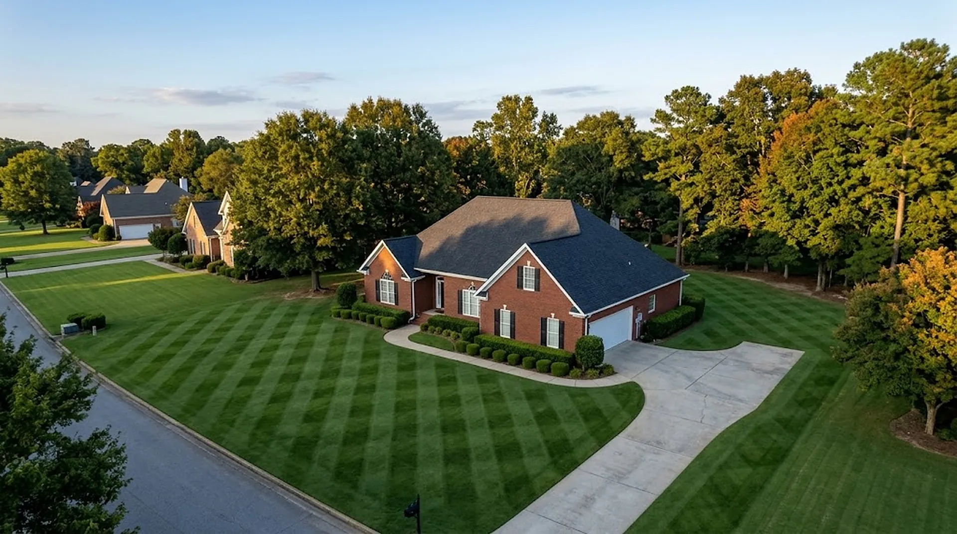 Aerial view of a brick house with a diamond-striped lawn